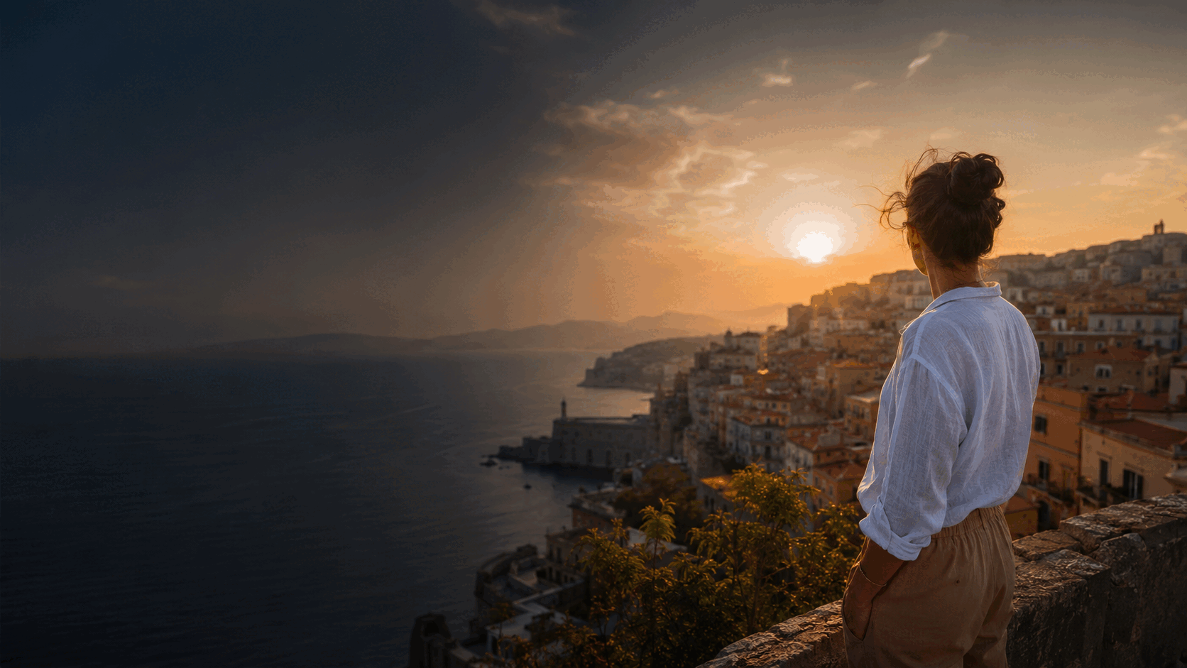 Traveler overlooking a Mediterranean city at golden hour